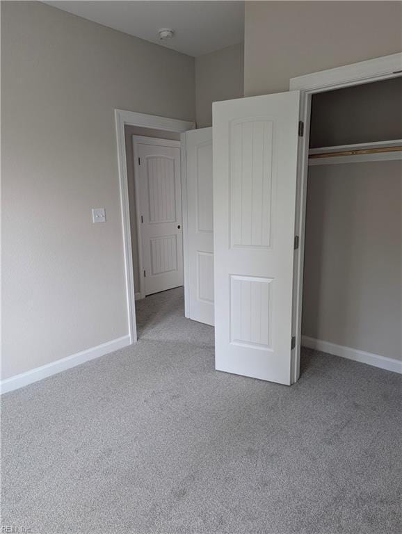 unfurnished bedroom featuring light carpet and a closet