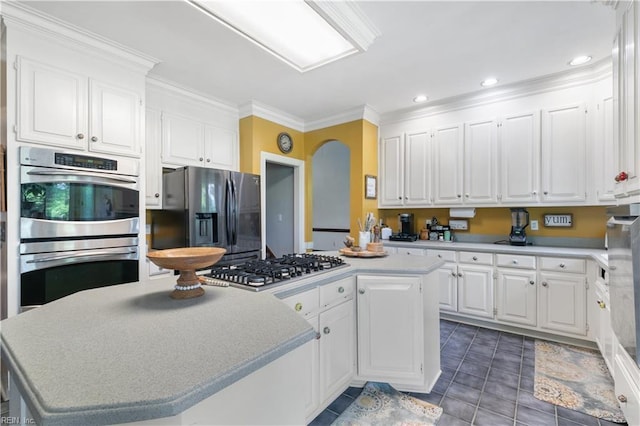 kitchen with white cabinetry, tile patterned floors, a kitchen island, and stainless steel appliances