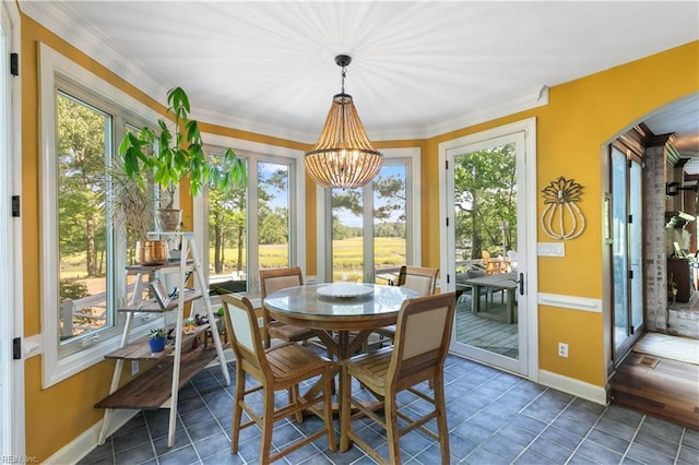 sunroom / solarium with arched walkways and an inviting chandelier