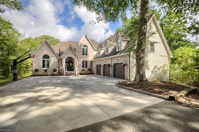 view of front of property with an attached garage, brick siding, and driveway