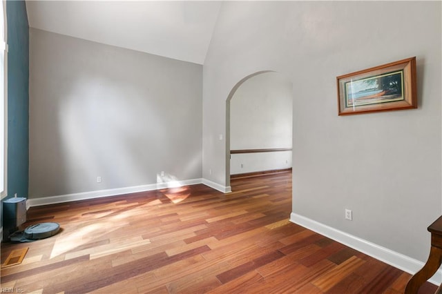 empty room featuring hardwood / wood-style flooring and vaulted ceiling