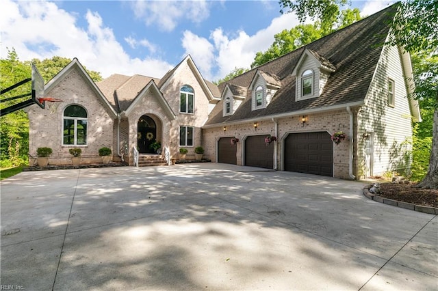 view of front of property with a garage, brick siding, and driveway