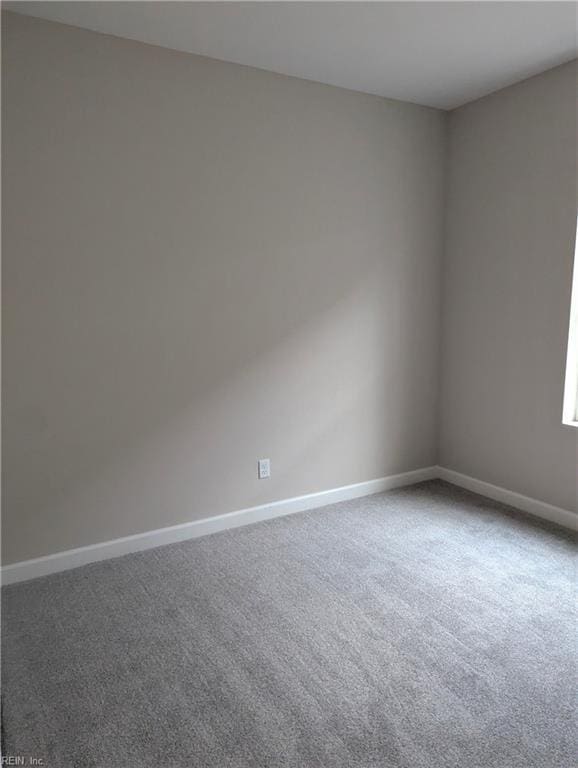 spare room with baseboards and carpet flooring