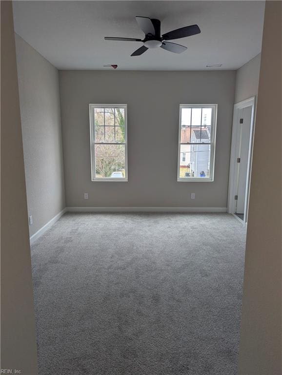 carpeted empty room with ceiling fan and baseboards