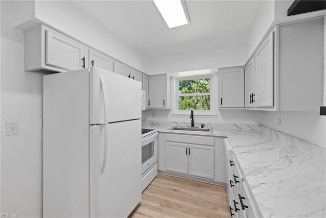 kitchen featuring light hardwood / wood-style flooring, light stone counters, sink, and white appliances