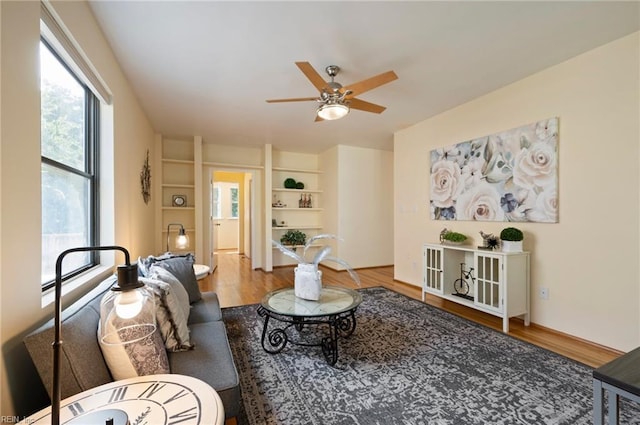 living room featuring wood-type flooring and ceiling fan