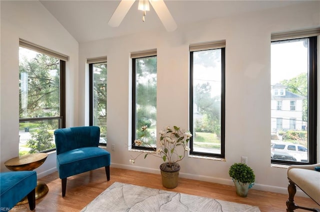 living area featuring a wealth of natural light, ceiling fan, and vaulted ceiling