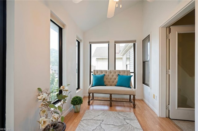 living area featuring lofted ceiling, ceiling fan, and light hardwood / wood-style flooring