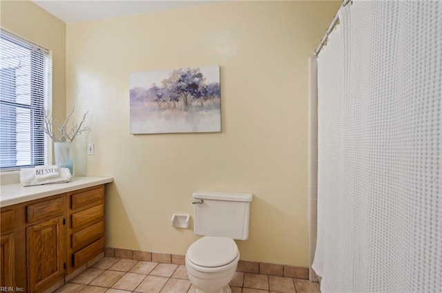 bathroom with vanity, toilet, curtained shower, and tile patterned flooring