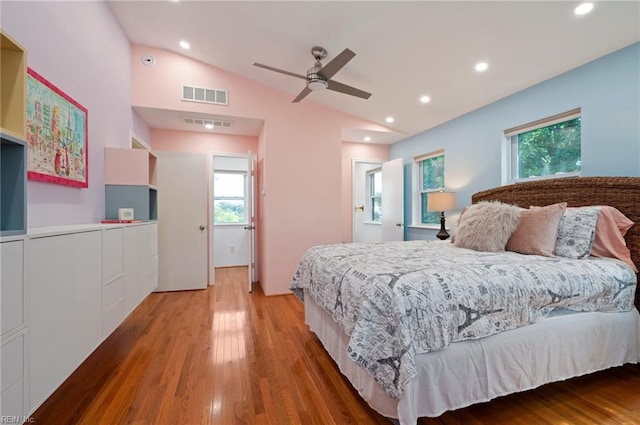 bedroom with vaulted ceiling, hardwood / wood-style floors, ceiling fan, and multiple windows