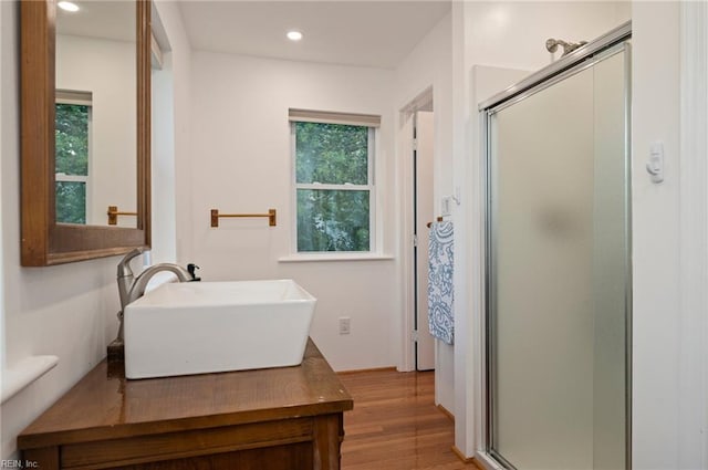 bathroom with an enclosed shower, hardwood / wood-style flooring, and a healthy amount of sunlight