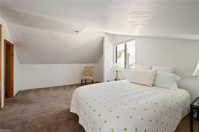 bedroom featuring lofted ceiling and carpet