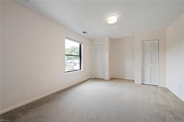 interior space with light carpet and two closets