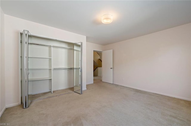 unfurnished bedroom featuring light carpet and a closet