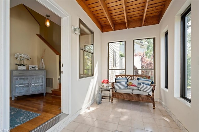 unfurnished room with wood ceiling, light hardwood / wood-style flooring, a healthy amount of sunlight, and beam ceiling