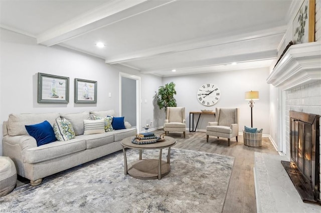 living room featuring a fireplace, beam ceiling, and light hardwood / wood-style flooring