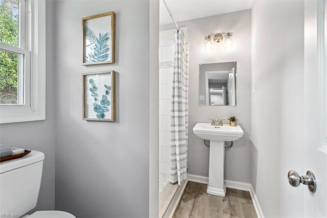 bathroom with a shower with curtain, toilet, and hardwood / wood-style flooring