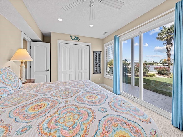 bedroom featuring a closet, ceiling fan, access to outside, and a textured ceiling