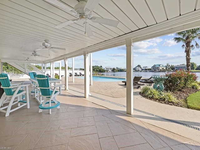 view of patio with ceiling fan and a water view