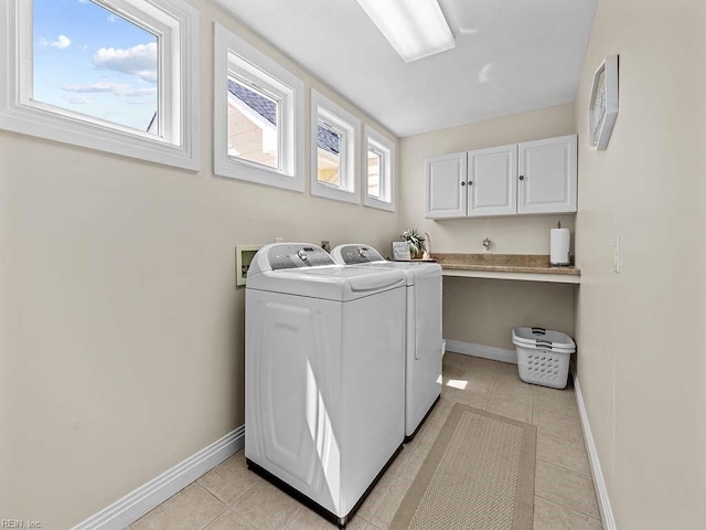 laundry area with cabinets, washer and clothes dryer, and light tile patterned flooring