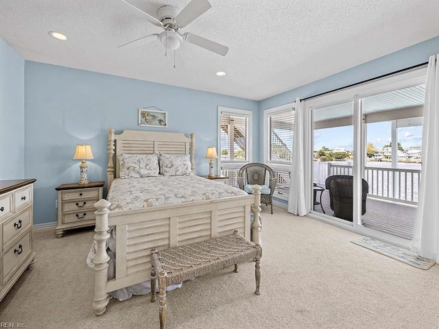 carpeted bedroom featuring ceiling fan, access to exterior, and a textured ceiling