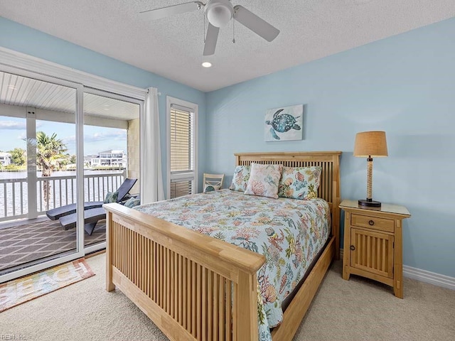 carpeted bedroom with ceiling fan, access to outside, and a textured ceiling