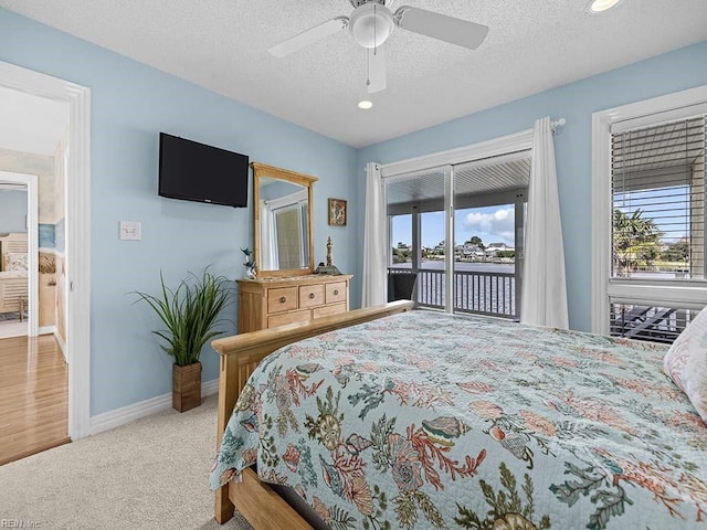 carpeted bedroom with a textured ceiling, access to exterior, and ceiling fan