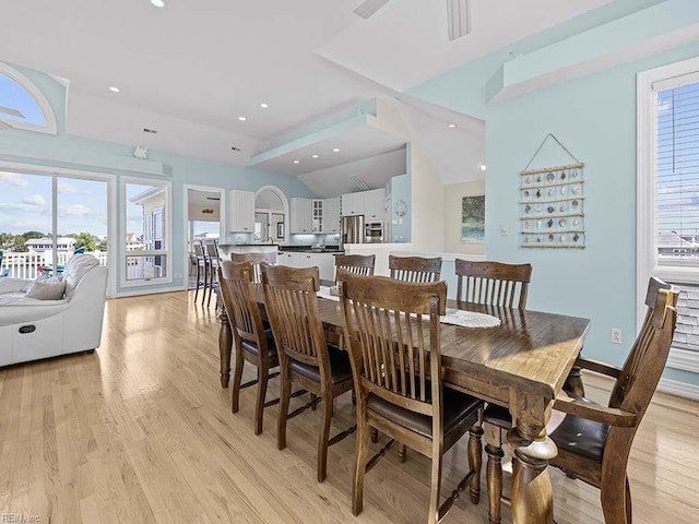 dining space with lofted ceiling and light hardwood / wood-style flooring