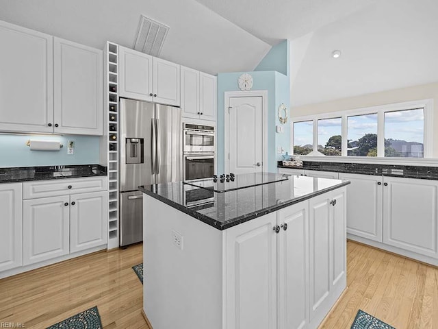 kitchen with light hardwood / wood-style flooring, appliances with stainless steel finishes, and white cabinets