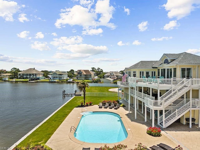 view of swimming pool with a lawn, a patio, and a water view