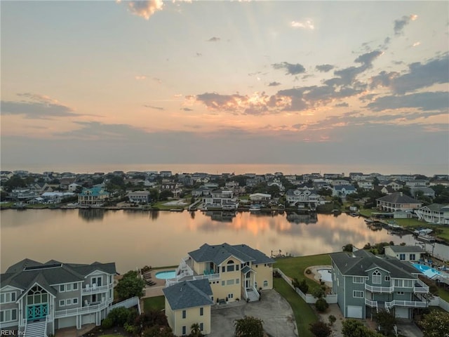 aerial view at dusk featuring a water view