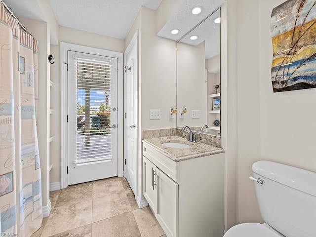 bathroom featuring a textured ceiling, vanity, toilet, and a shower with shower curtain