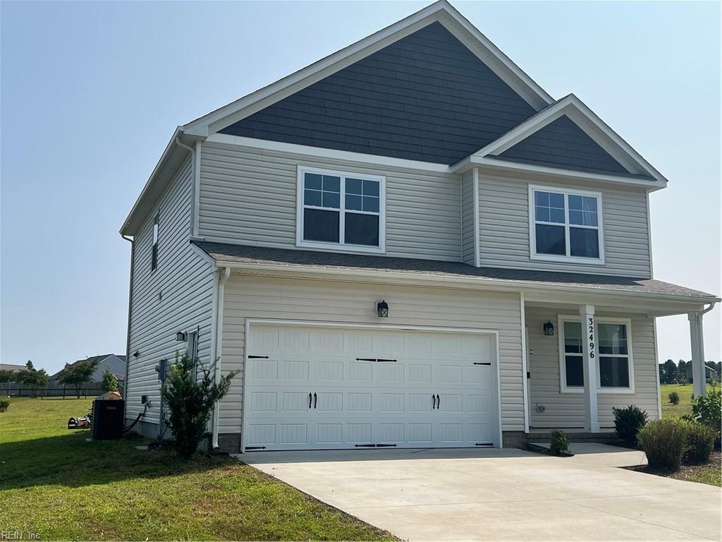 view of front of home featuring a garage, central AC unit, and a front lawn