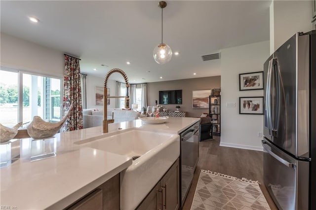 kitchen featuring sink, pendant lighting, stainless steel appliances, and hardwood / wood-style flooring