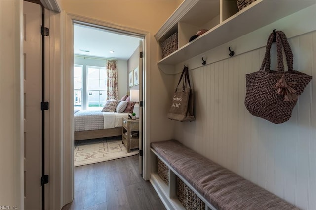 mudroom featuring wooden walls and dark wood-type flooring