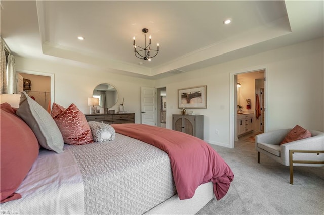 bedroom featuring an inviting chandelier, connected bathroom, a raised ceiling, and light carpet