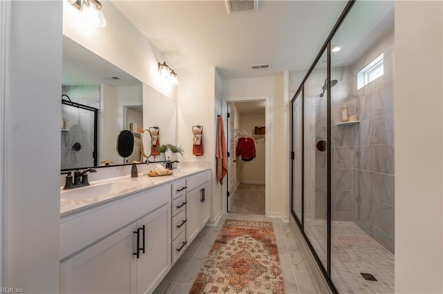 bathroom featuring tile patterned floors, a shower with shower door, and vanity