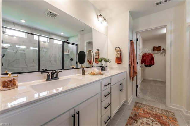 bathroom featuring tile patterned flooring, walk in shower, and vanity