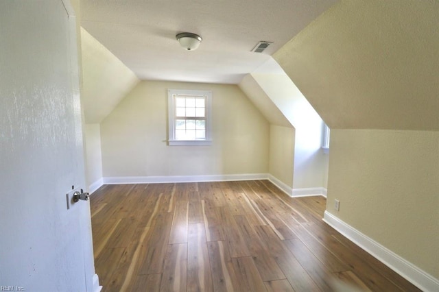 additional living space featuring lofted ceiling and dark hardwood / wood-style floors