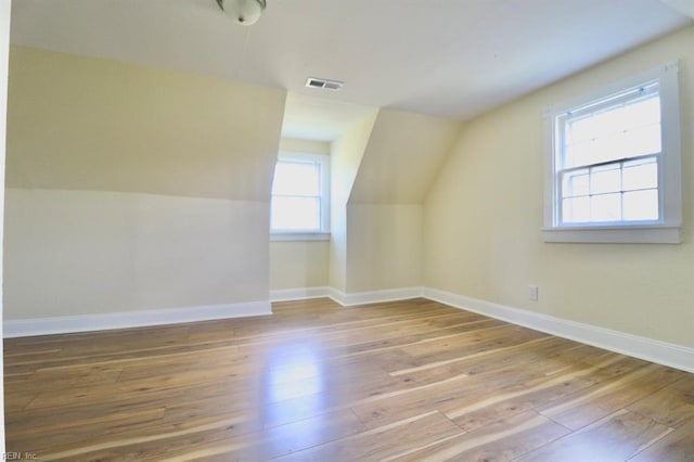 additional living space featuring lofted ceiling and hardwood / wood-style floors