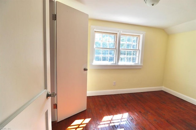 spare room with lofted ceiling and dark hardwood / wood-style floors