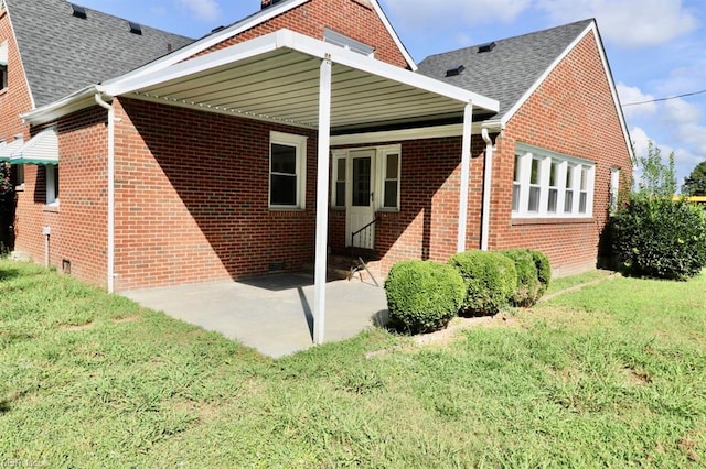 rear view of property with a lawn and a patio area