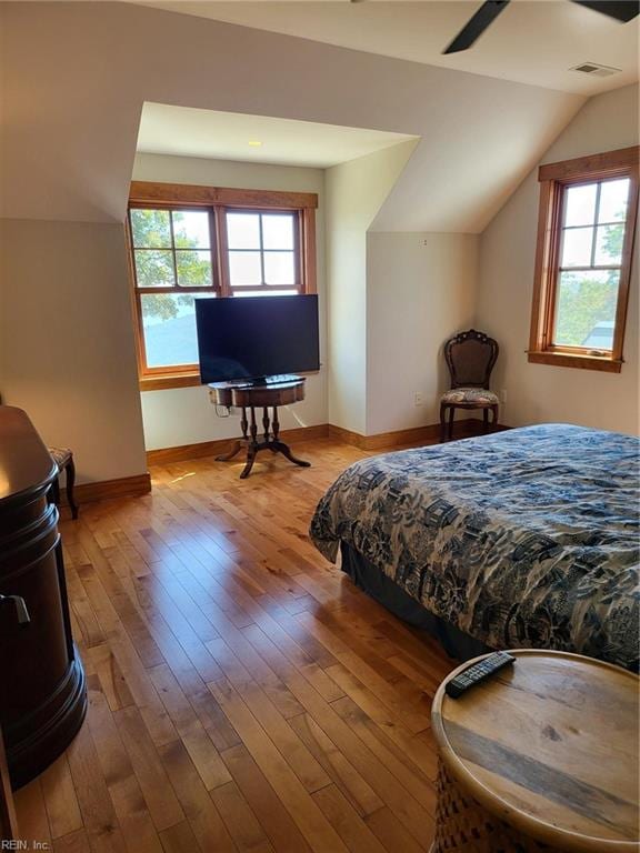 bedroom with ceiling fan, lofted ceiling, light hardwood / wood-style floors, and multiple windows