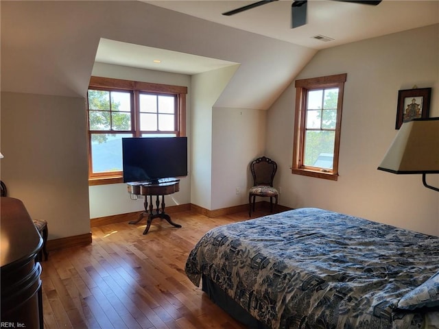 bedroom featuring lofted ceiling, multiple windows, hardwood / wood-style flooring, and ceiling fan