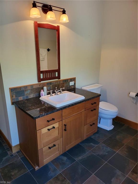 bathroom with tile patterned floors, backsplash, vanity, and toilet