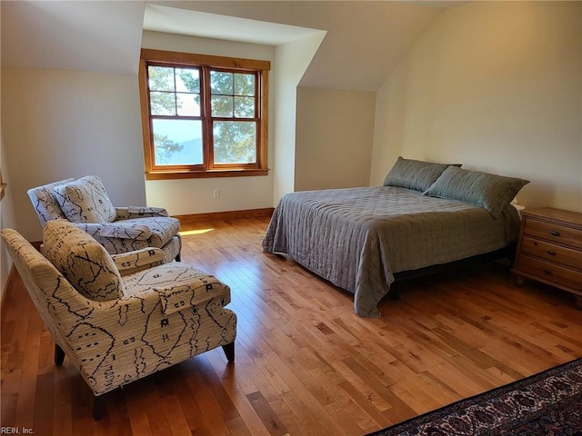 bedroom with light hardwood / wood-style flooring and vaulted ceiling