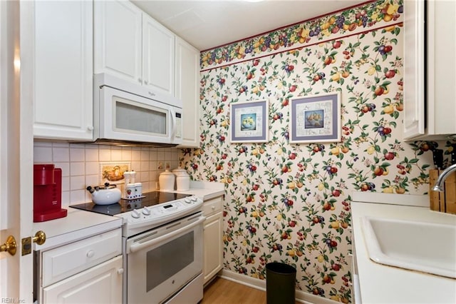 kitchen featuring decorative backsplash, light hardwood / wood-style floors, white cabinetry, white appliances, and sink