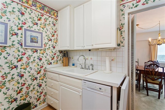 kitchen with an inviting chandelier, white dishwasher, white cabinetry, and sink