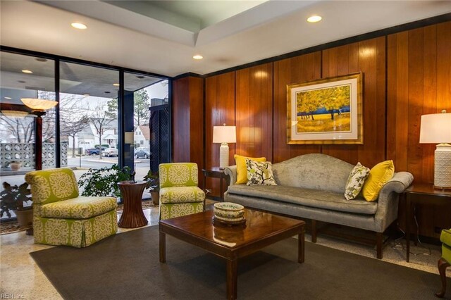 living room with a wall of windows and wood walls