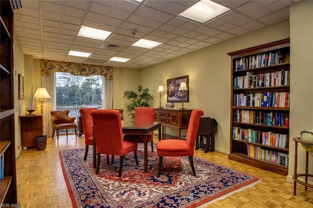 dining space with light parquet floors and a paneled ceiling